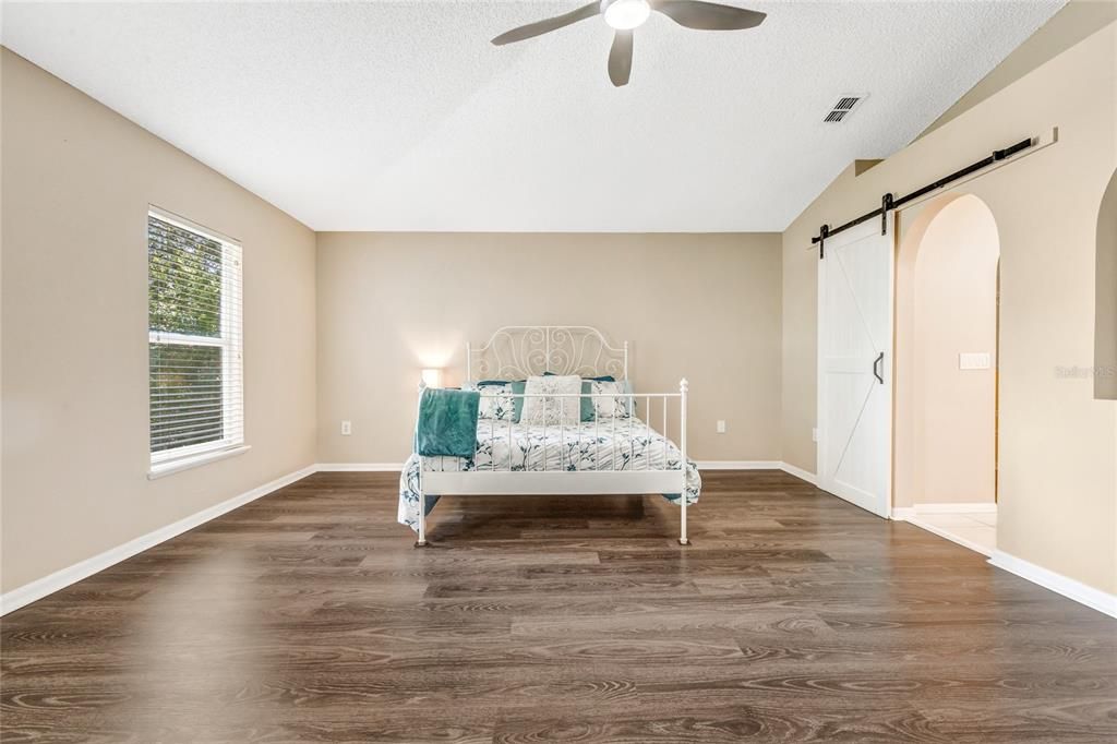 primary bed with ceiling fan and an en-suite bath