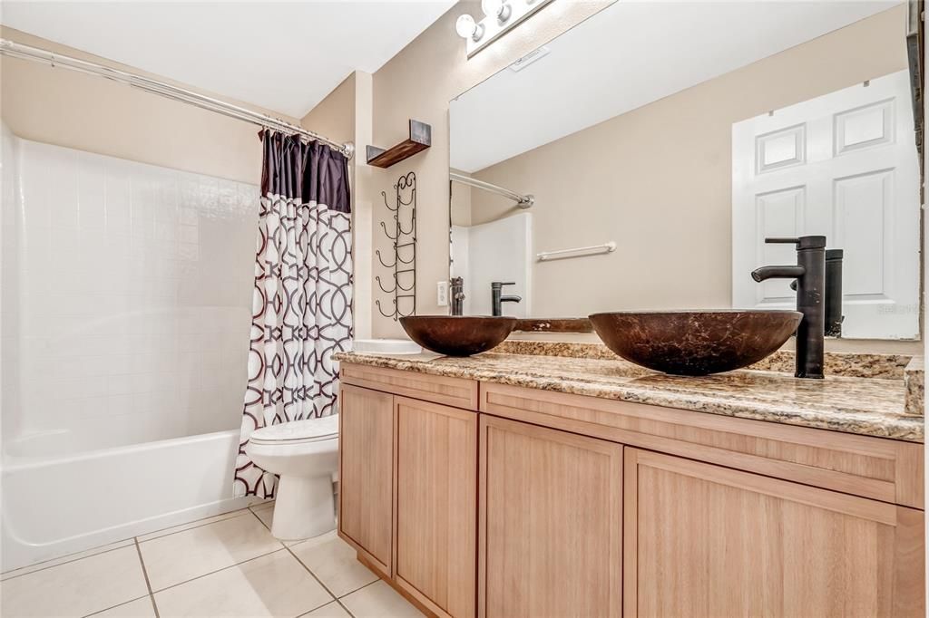 dual sink vanity area, a standing shower and tub