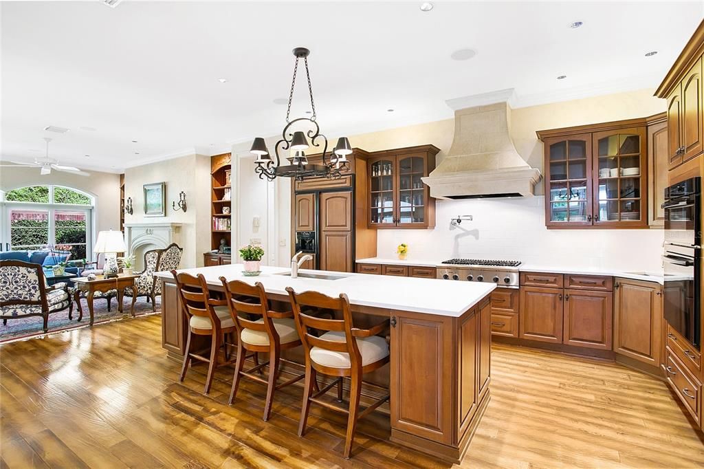 Beautifully designed kitchen with solid wood cabinetry, island sink, pot filler, prep sink and custom range hood.  Thermador Professional Gas Cooktop, Profile wall oven/microwave combo, Kitchenaid Refrigerator, and Bosch dishwasher.