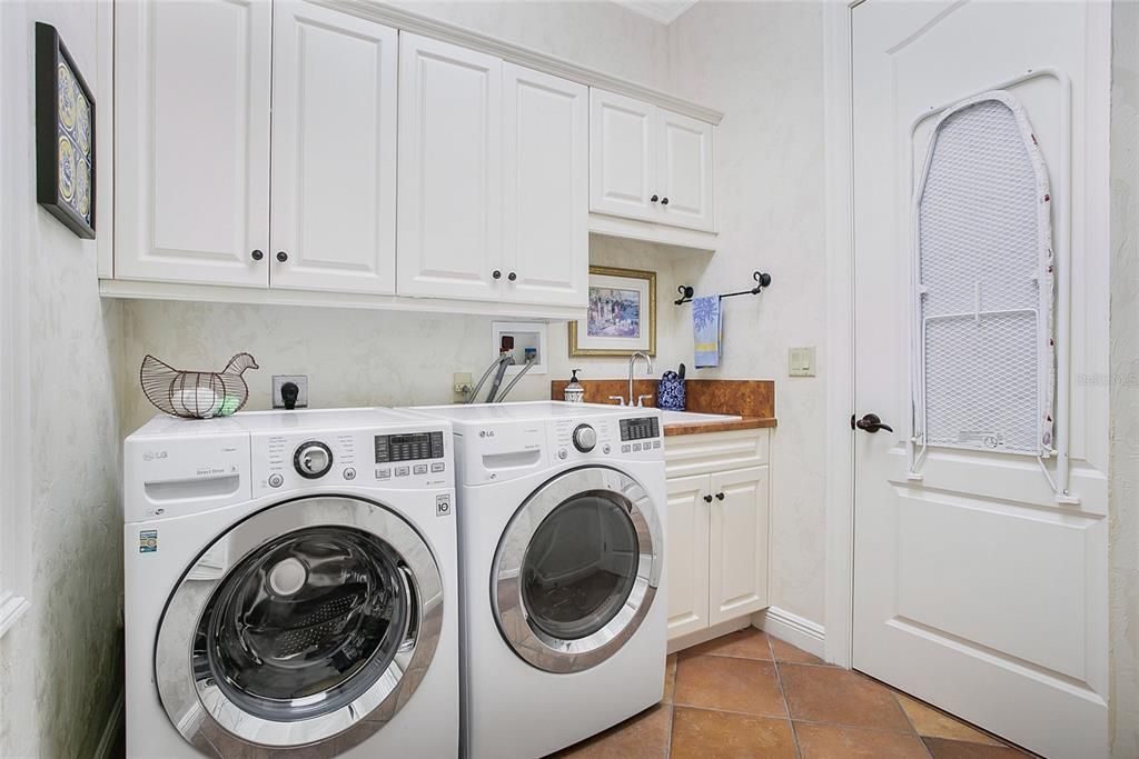 Spacious laundry room with custom cabinets and laundry sink