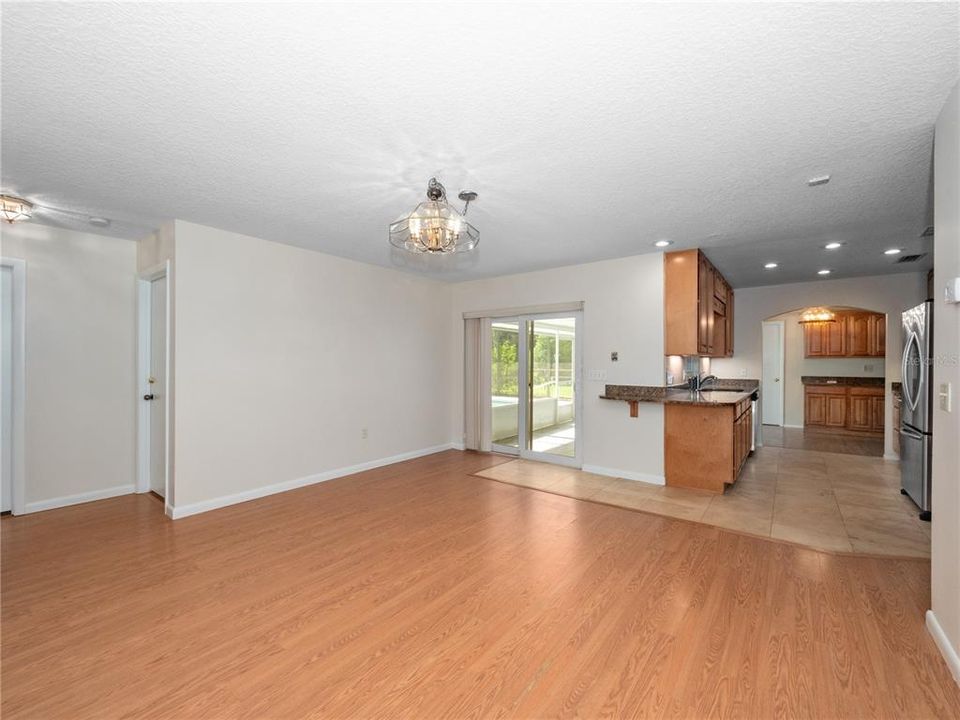 Family room with sliders to screened porch, pool and spa.  Bar seating in the kitchen