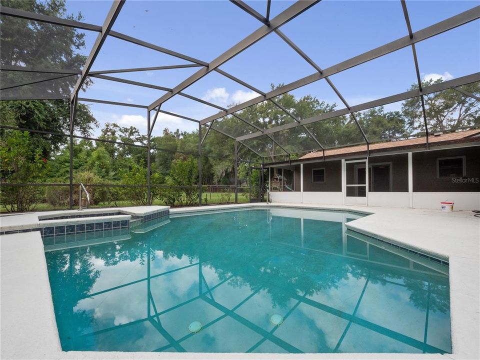 Large screened porch overlooks screen covered pool and spa.