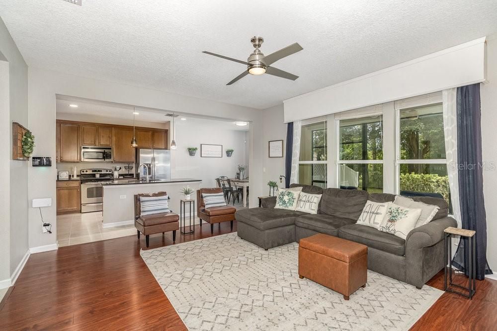 Open concept Family room with Engineered wood flooring, and ceiling fan and opens into Kitchen.