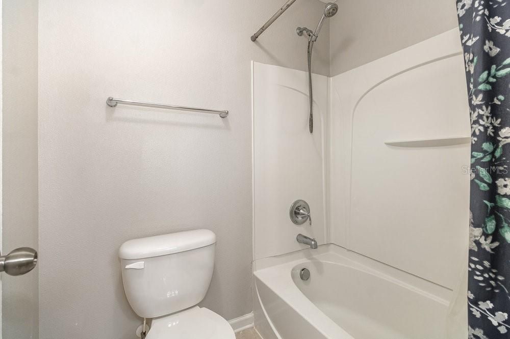 Guest Bathroom with Corian counter and Tub/shower combo.