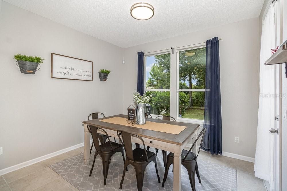 Dinette with tiled flooring and French door to back screened porch.