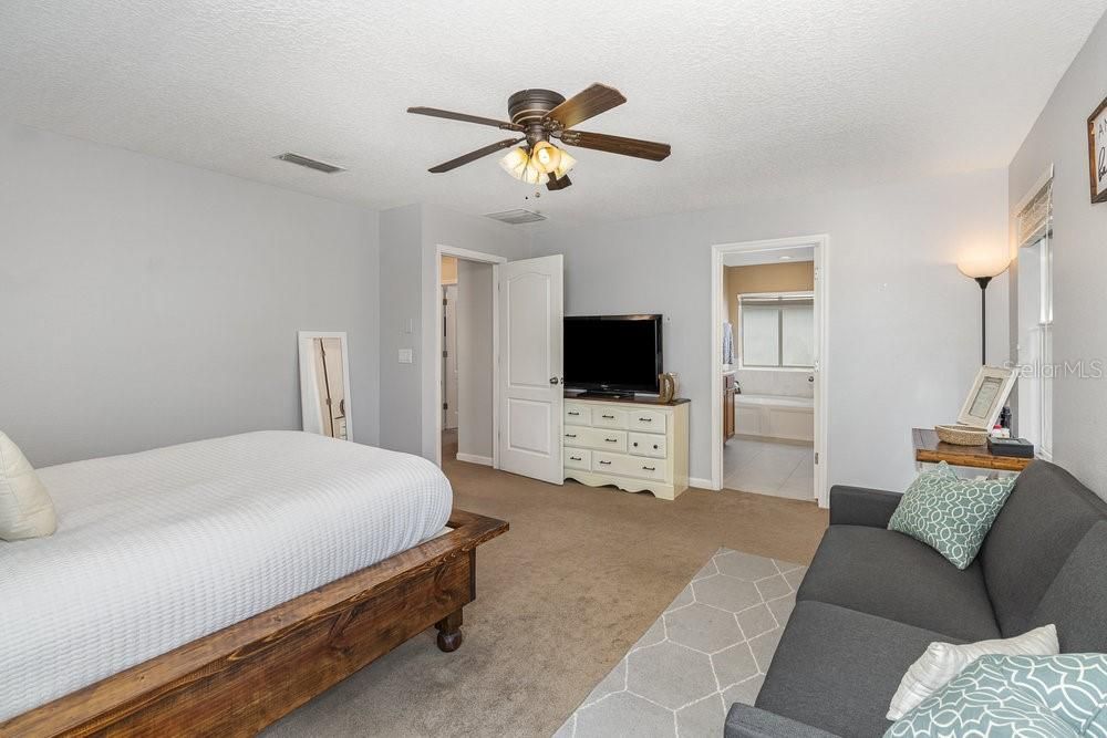 Primary Bedroom with En Suite bathroom, ceiling fan and Walk-in closet.