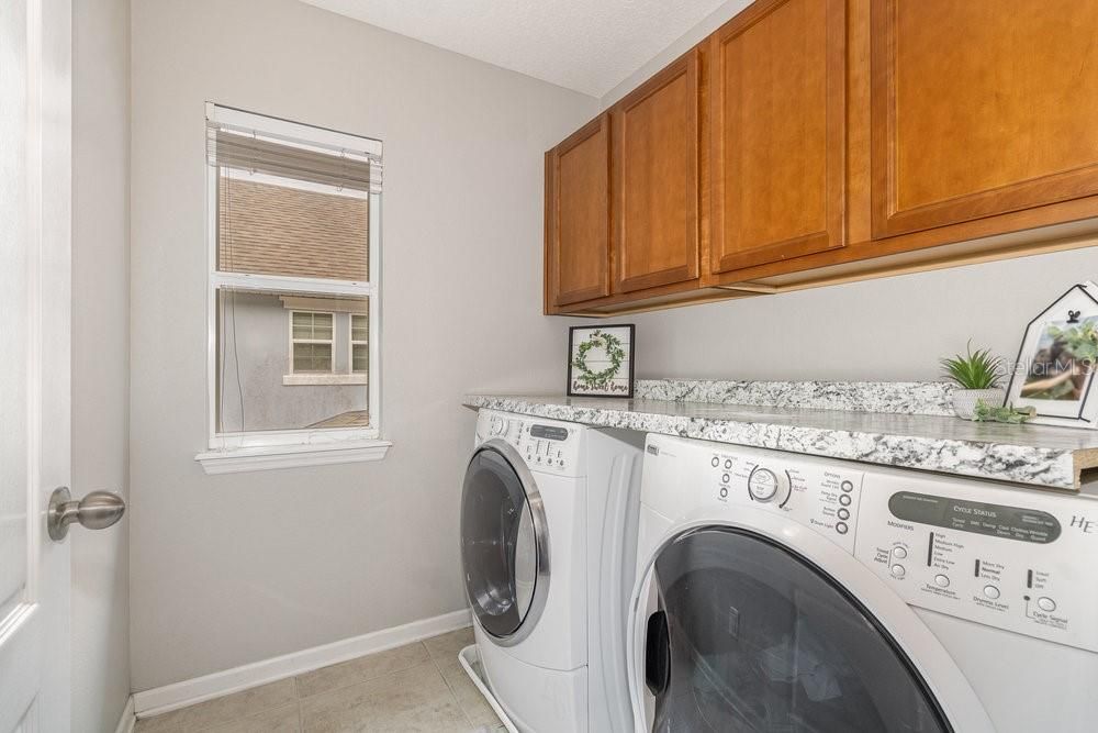 Second floor Laundry Room with counter and cabinet storage.