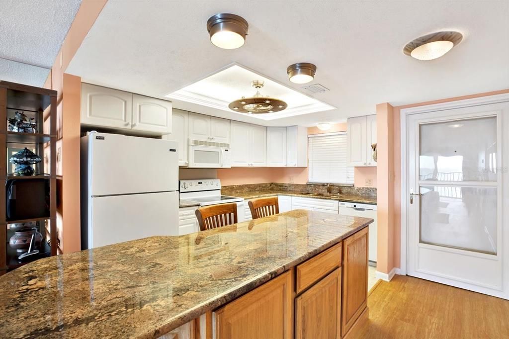 Kitchen features white cabinets and granite countertops