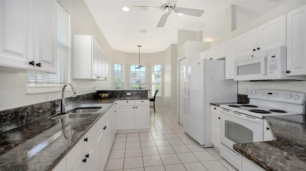 Featuring white raised panel cabinetry and granite countertops