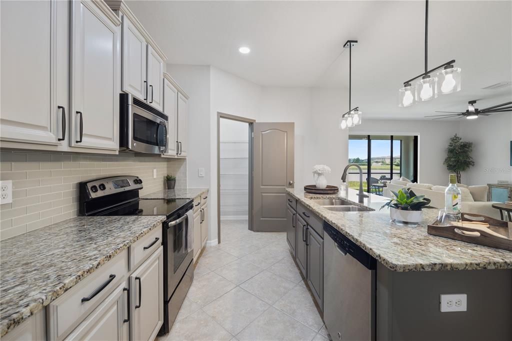 Stunning two toned Custom Painted cabinets with 4" cabinet pulls and glass tile backsplash and decor switchplates and Decor swtiches with no screws in the plates!