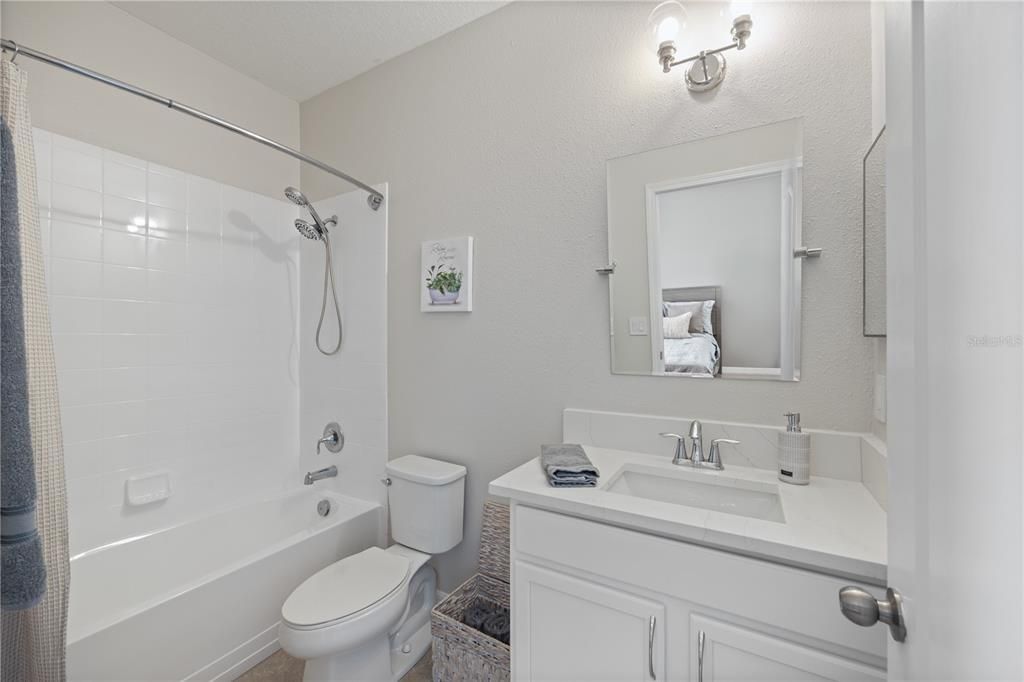 Guest bath 2, level4 quartz countertops, white and bright with new light fixtures and mirror