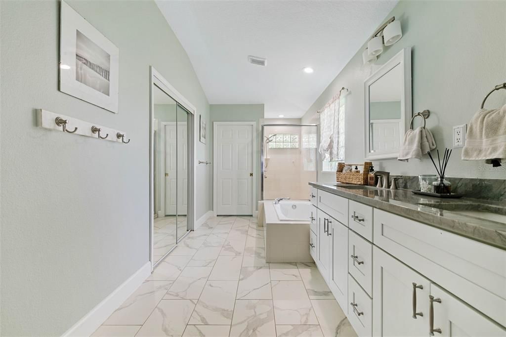 Updated bright and primary bath with custom stone countertops. Updated tile, soaking tup and private enclosed commode area.