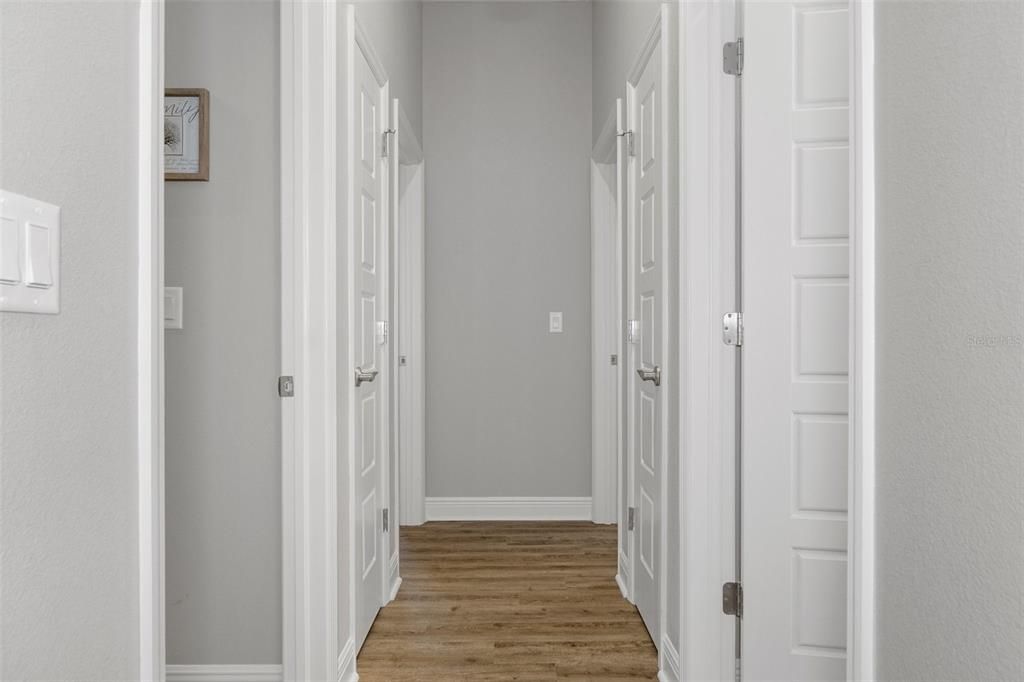 Hallway to guest bath on right, hall closets, and two guest bedrooms at the end of the hall.