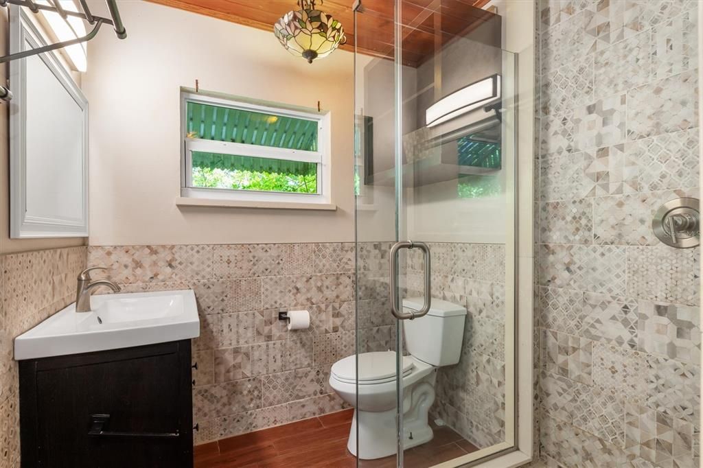 Updated guest bathroom with roomy tiled shower.