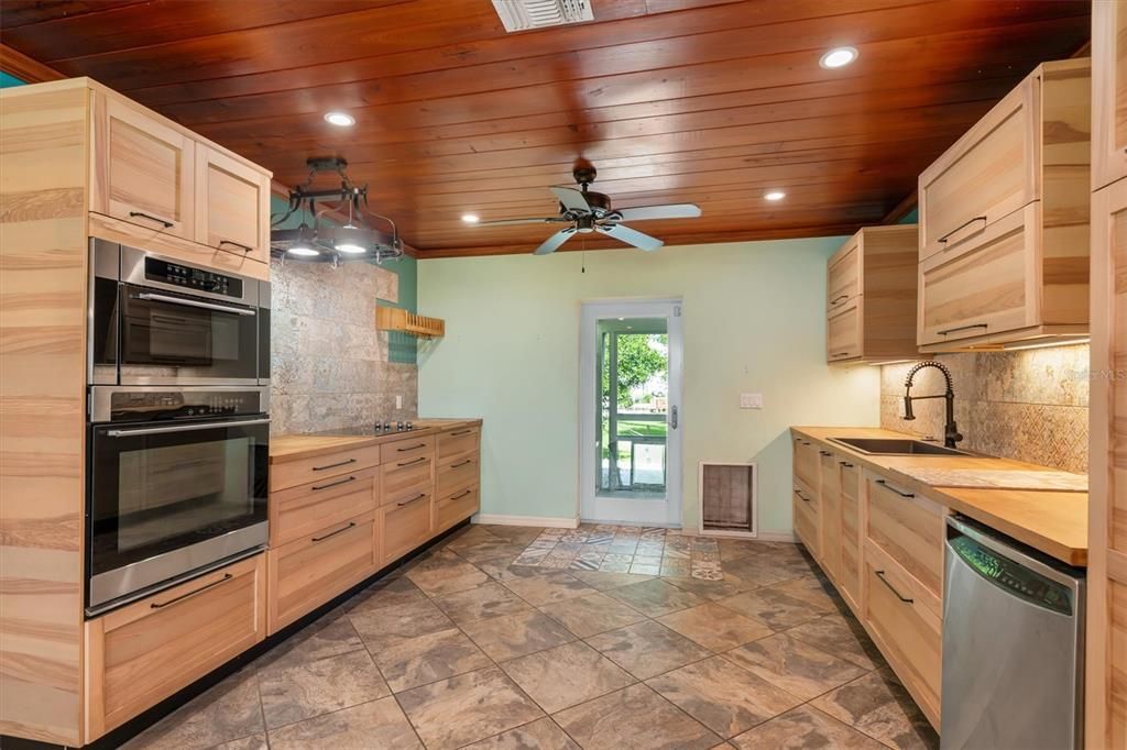 Warm wood tones and plank wood ceiling add to the mid-century charm maintained after complete update to kitchen.