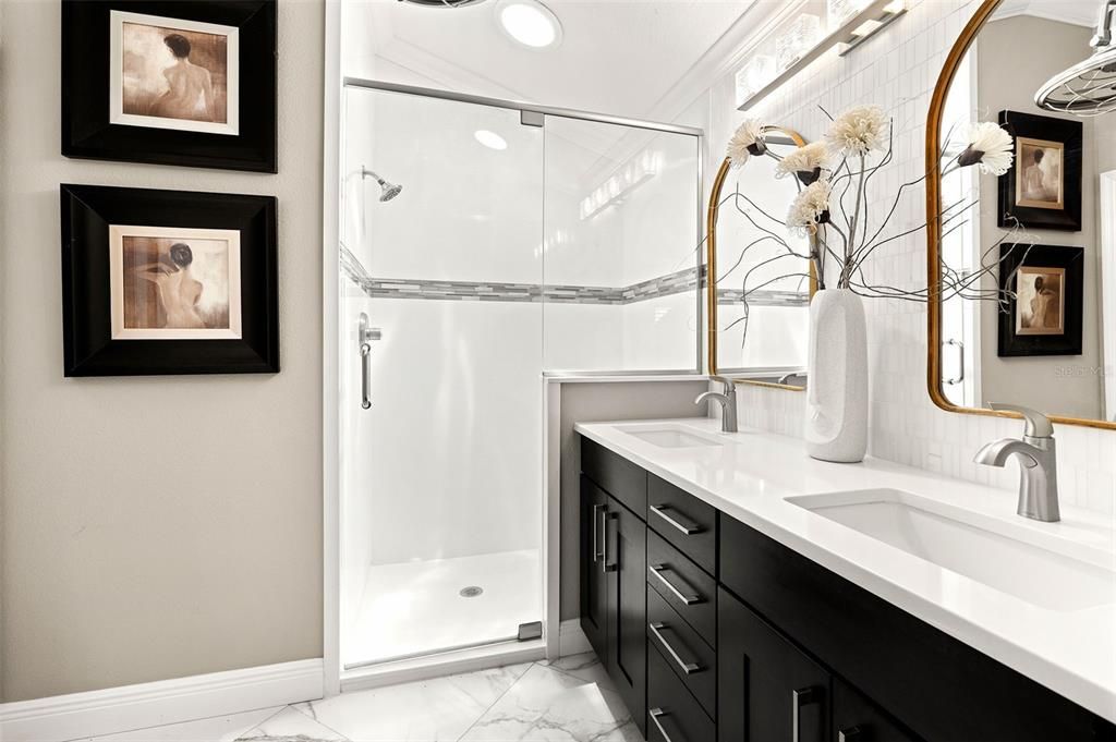 The ensuite bathroom features dual sinks with quartz countertops, a glass walk-in shower, and a separate toilet room.