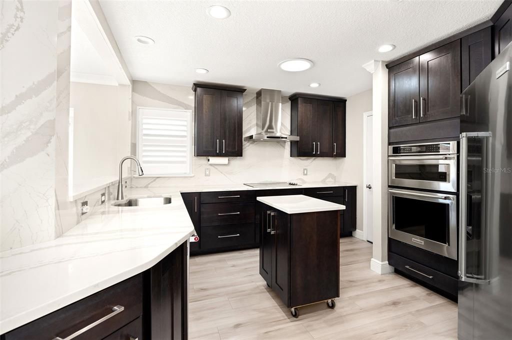 Sleek quartz countertops that provide ample workspace, complemented by contemporary cabinetry and top-of-the-line appliances can be found in the kitchen.