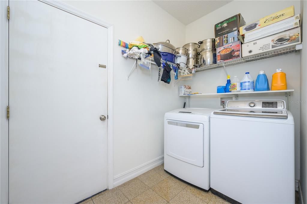 Nice size laundry area with shelving off the kitchen next to garage entry door.