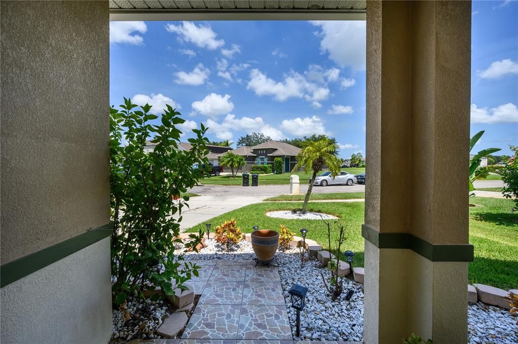 View of front Tiled entry and landscaping looking toward neighbor across street