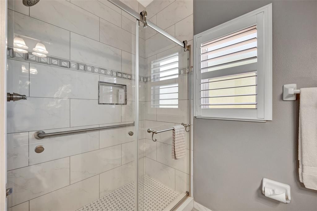 Guest bath with full walk in shower features floor to ceiling tiles