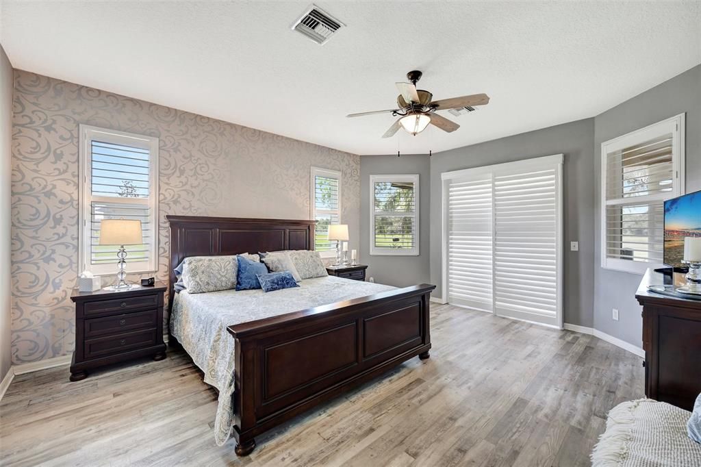 Primary suite with ceiling fan and plantation shutters