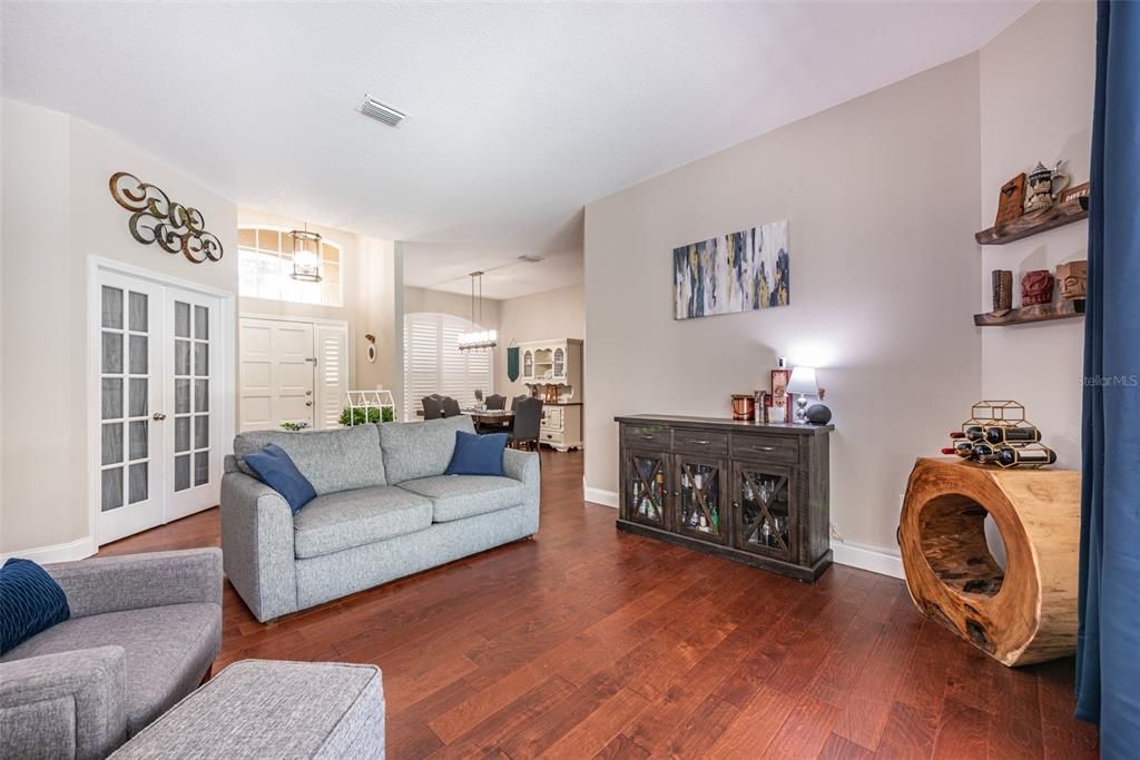 View of Living room, dining room, office door, and front door with side light and transom window.