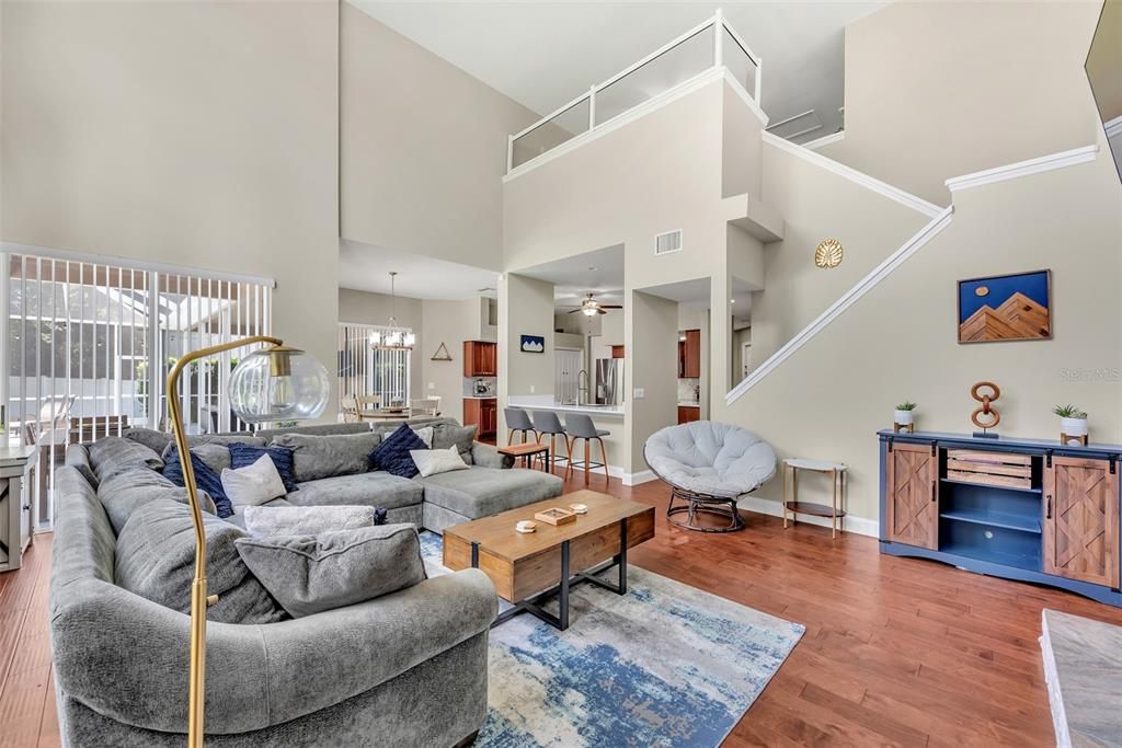 View of family room/kitchen and stairs to bonus room loft and 2 more bedrooms and a full bathroom on the 2nd level.  The clear half wall extension on the loft was custom made for peace of mind without sacrificing the natural light.