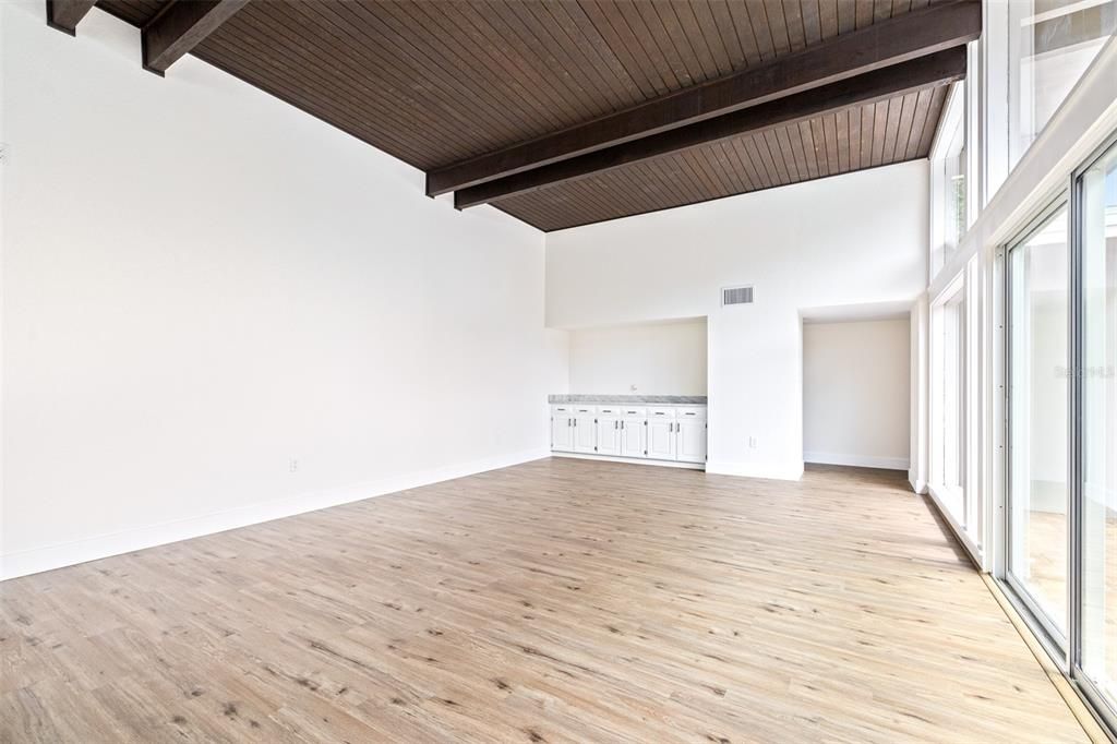 Family Room w/12' ceilings, built-in, and massive display windows/doors