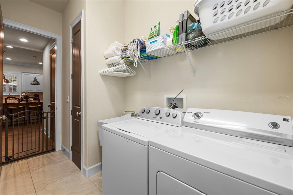 large indoor laundry room with utility sink & storage closet right off of kitchen