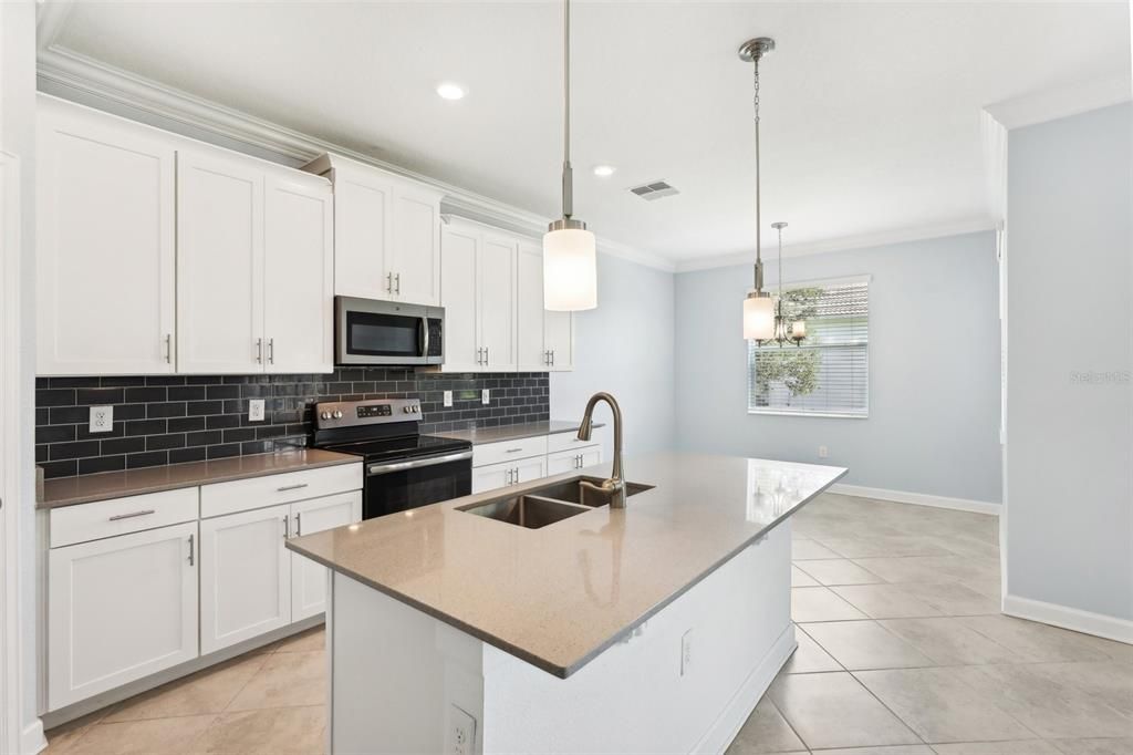 The Kitchen has STONE COUNTERTOPS, an OVERSIZED ISLAND, STAINLESS STEEL APPLIANCES, UPGRADED CABINETRY and BEAUTIFUL TILE BACKSPLASH.