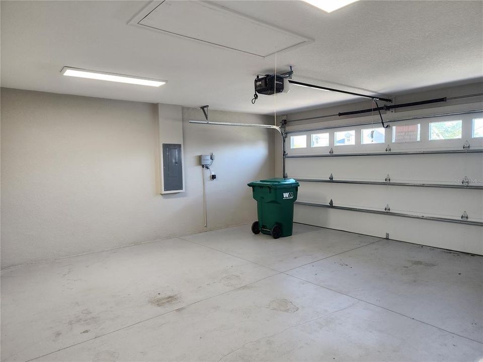 2-Car Garage with pull-down attic stairs and windows in the garage door