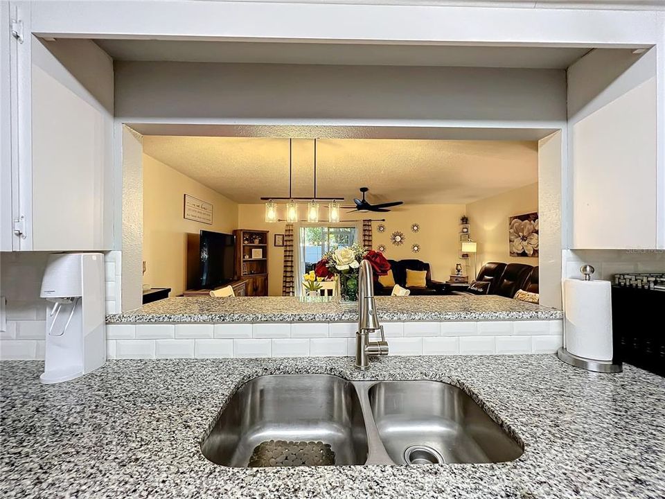 Kitchen "window" overlooking the breakfast bar, dining area, and living room.