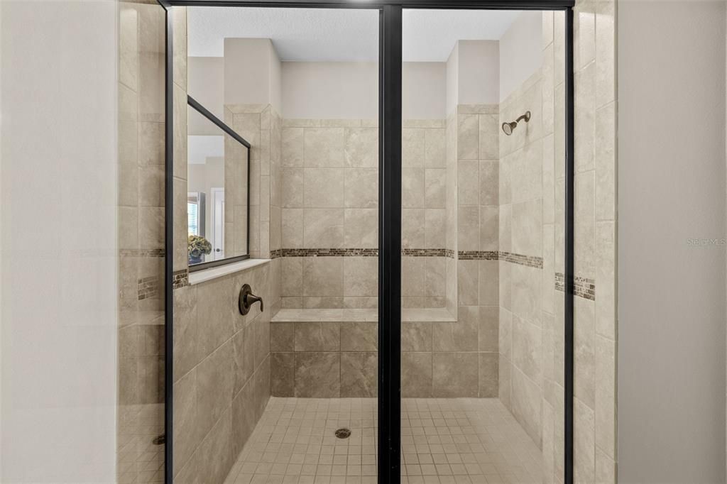 Tiled master shower with built-in shower bench