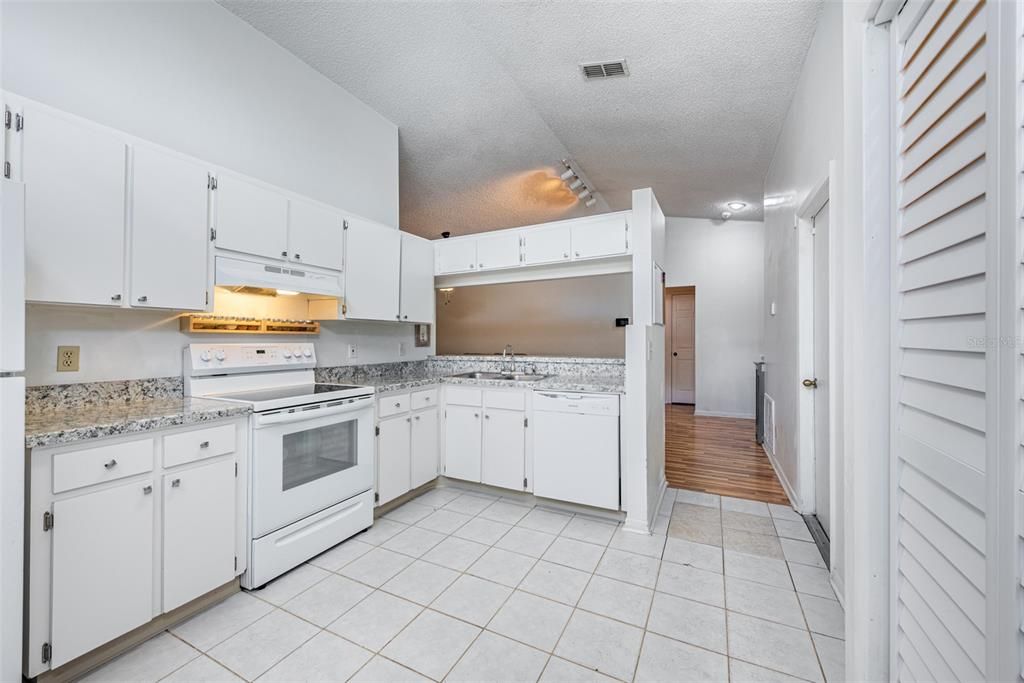 The kitchen is equipped with newer white appliances, an Extended Breakfast Bar, and sprawling counters for meal prep.