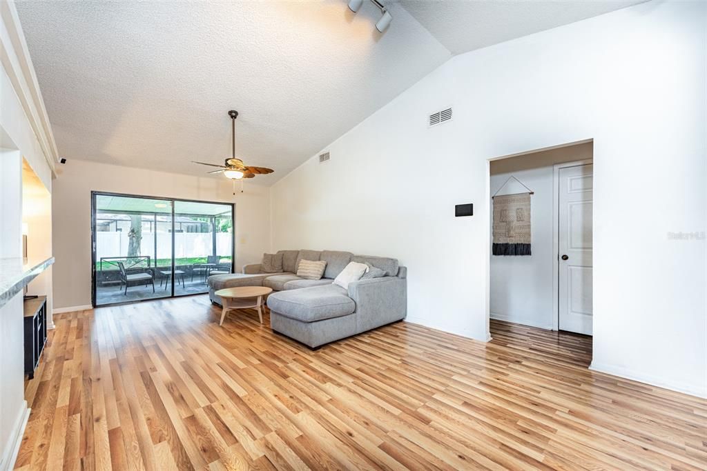 Loads of natural light fill the open floor plan with a sightline to the screened lanai and vast fenced backyard beyond.