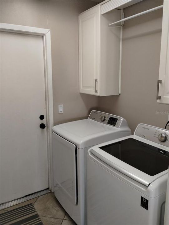 Indoor laundry room has extra cabinets!