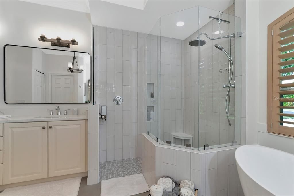 Beautifully updated shower with new hardware, tile and glass shower door.