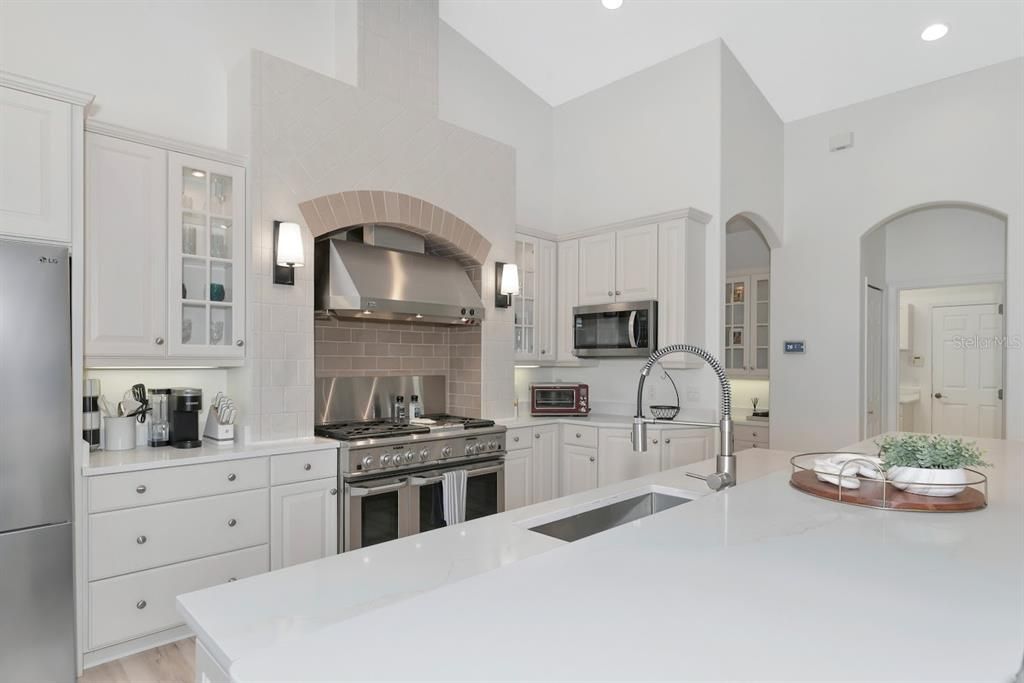 Beautiful quartz countertops, custom cabinets with glass inserts and lighting.