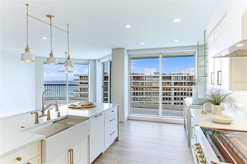 Sleek white cabinets and gold pulls bring a touch of elegance to this modern kitchen.