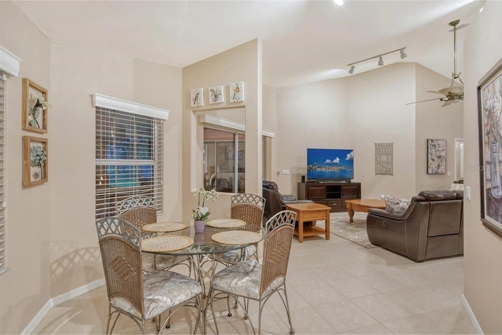 Kitchen featuring solid wood cabinets, polished granite countertops, stainless steel appliances, and a dinette.