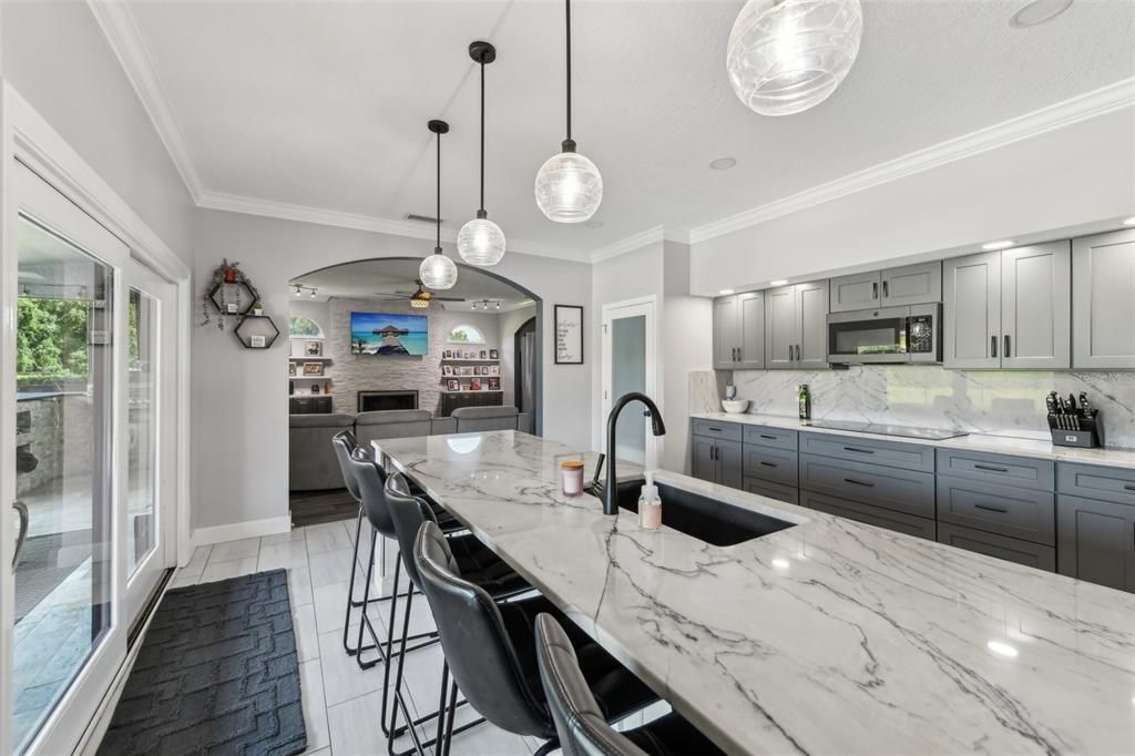 Kitchen features an island with plenty of room for seating and quartzite countertops