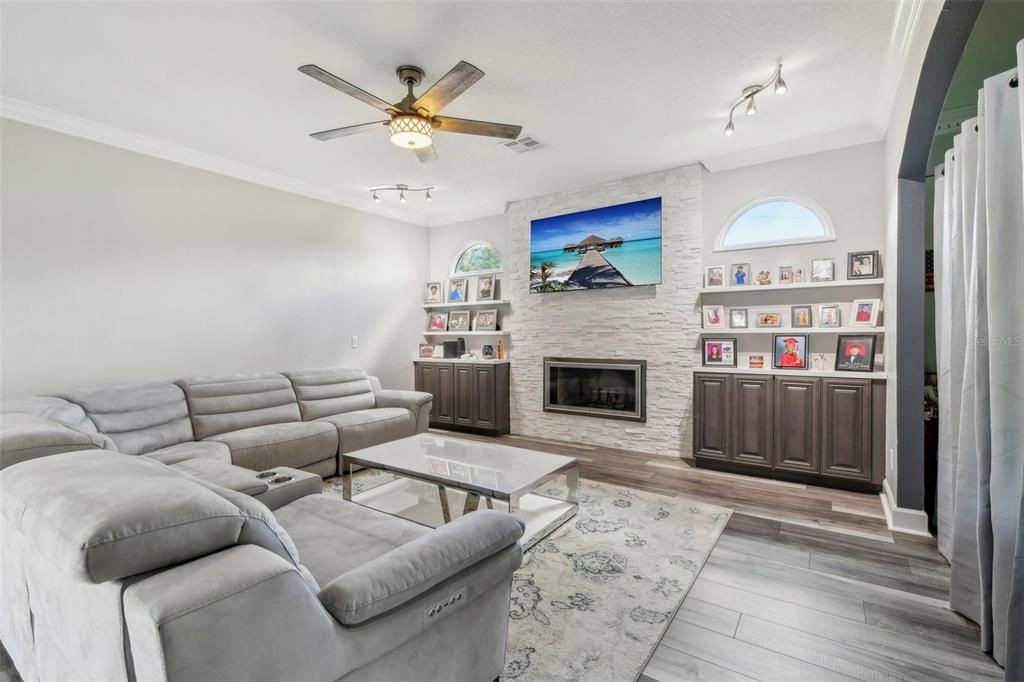 Family room off the kitchen with wood burning fireplace, stone accent detail and built-in storage