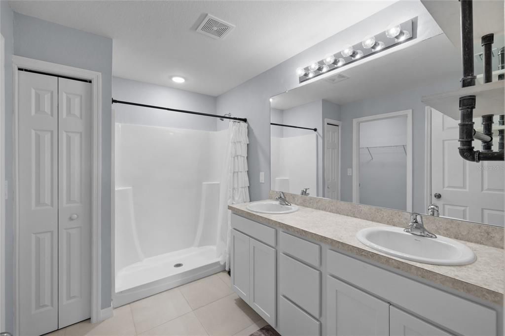 Sweet primary Bathroom with walk in Shower, Tile Flooring, and Dual Vanity