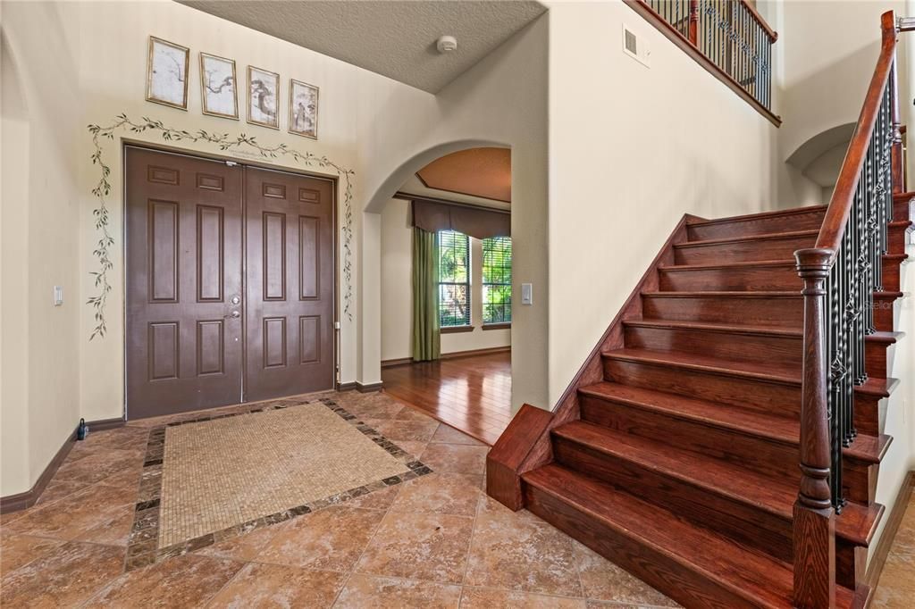 Foyer Entry; to your left is Dining areas, ahead is stairway and Living room, and to your right is bathroom, laundry, and second downstairs bedroom.