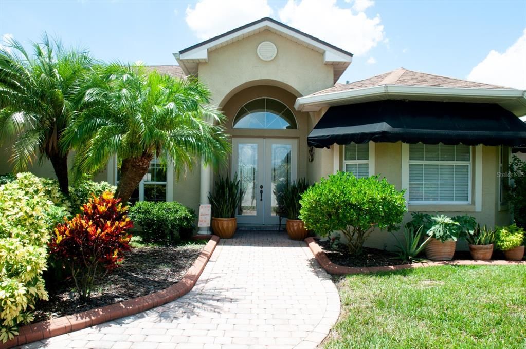 The double leaded glass front door is protected by an elevated covered front porch.