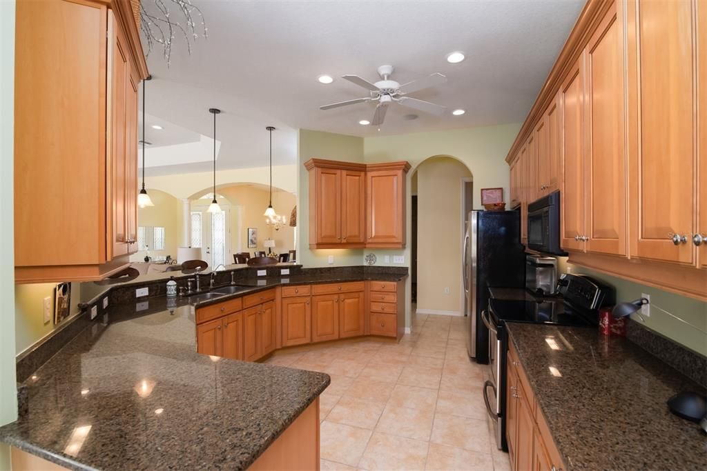 The kitchen features granite counters and ample maple cabinets with 42" uppers, crown, and pulls.