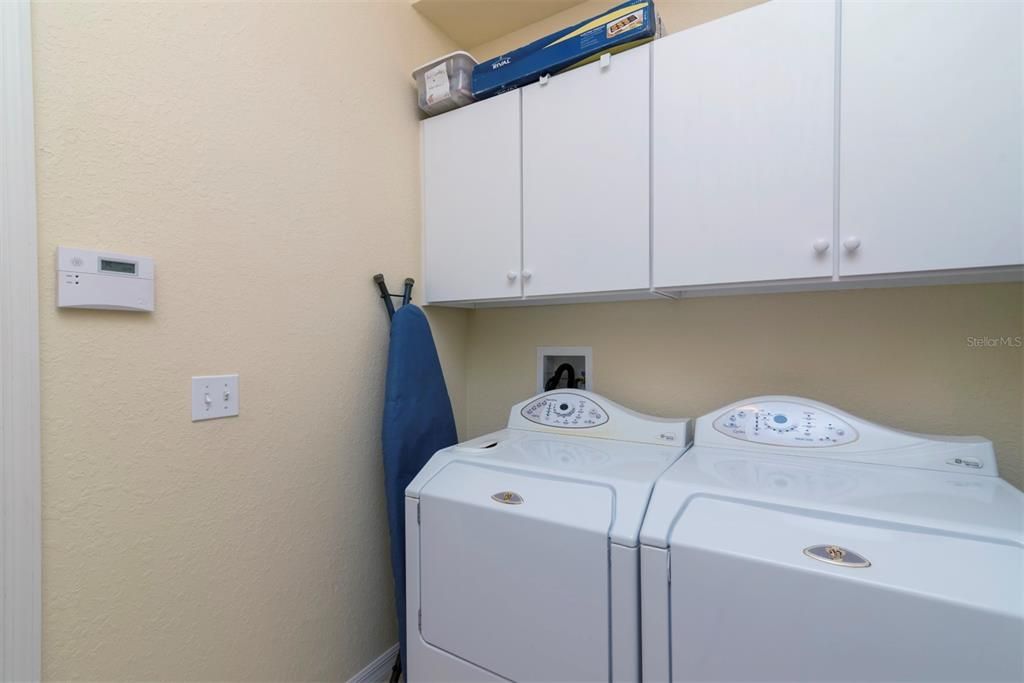 The laundry room has extra cabinetry. The washer and dryer stay for the new owners.