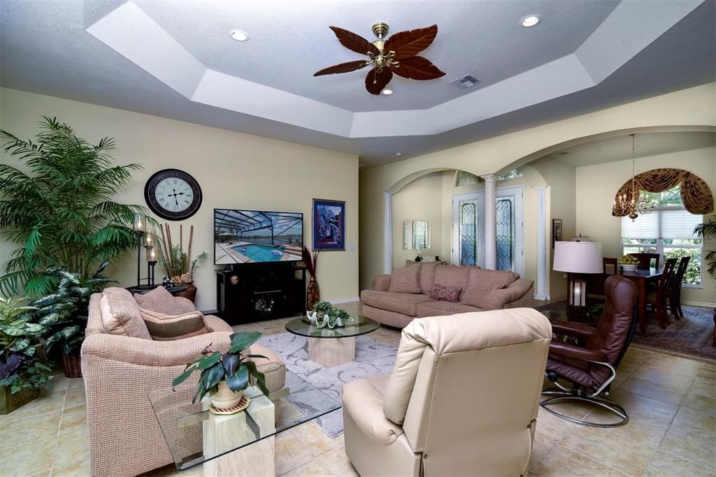 The living room has a tray ceiling with a designer ceiling fan.