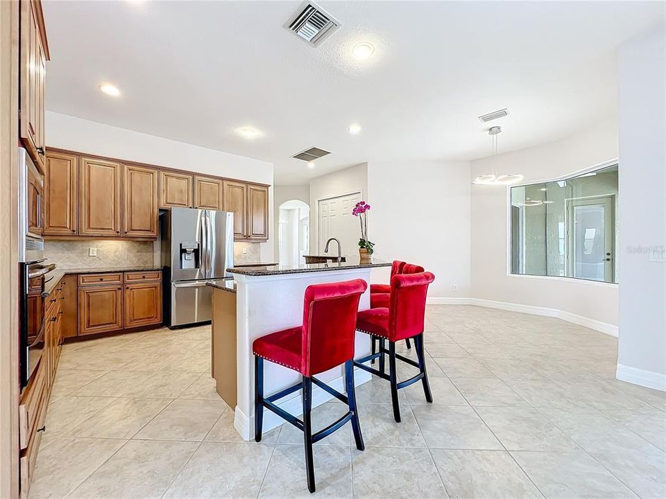 Café off kitchen w/ aquarium window overlooking pool spa & lake.