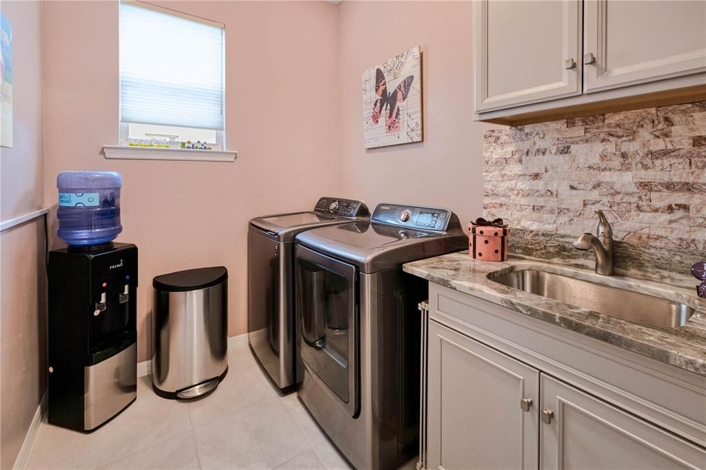 Convenient inside laundry complete with sink, granite counter and cabinets